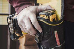 person holding black and yellow nike gloves