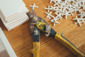 closeup photo of yellow and black handheld tool near white plastic locks
